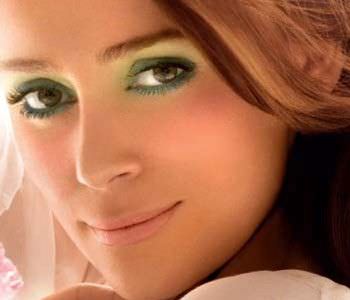 mujer con ojos morrones y maquillaje verde